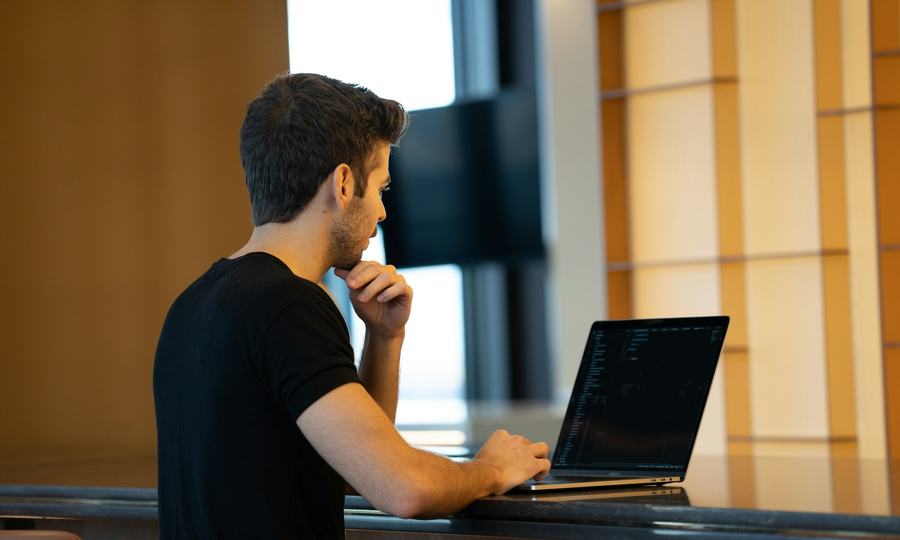 Persona sentada revisando datos con atención en la pantalla de su portátil